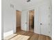 Bedroom with light wood floors, white walls, white doors, and access to a walk-in closet and bathroom at 905 N Willow Ave, Tampa, FL 33606