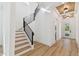 A view of the entry and staircase featuring light wood floors and contemporary black metal railings at 905 N Willow Ave, Tampa, FL 33606