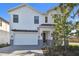 New home exterior showing light brick paver driveway, 2-car garage, landscaping, and white siding at 905 N Willow Ave, Tampa, FL 33606