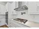 Kitchen detail featuring a gas range, custom hood, modern backsplash, and plenty of counter space at 905 N Willow Ave, Tampa, FL 33606
