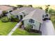 Aerial view of a green home with a well-manicured lawn and a brick walkway to the front door at 916 Bunker View Dr, Apollo Beach, FL 33572