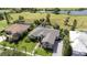 Aerial view of a green home near a lake, showcasing a manicured lawn and beautiful landscaping at 916 Bunker View Dr, Apollo Beach, FL 33572