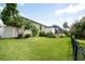 Well-manicured backyard featuring green grass, tropical foliage, and privacy fencing with a view of the house at 916 Bunker View Dr, Apollo Beach, FL 33572