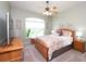Charming bedroom with floral bedding, ceiling fan, and bright window, creating a cozy and inviting space at 916 Bunker View Dr, Apollo Beach, FL 33572
