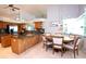 Dining area with round wood table, upholstered chairs, and oak cabinets at 916 Bunker View Dr, Apollo Beach, FL 33572