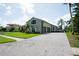 Exterior shot of a light green home, highlighting the driveway and well-maintained lawn at 916 Bunker View Dr, Apollo Beach, FL 33572