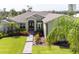 Beautifully landscaped front yard featuring lush green lawn, colorful flower beds, and a charming walkway at 916 Bunker View Dr, Apollo Beach, FL 33572