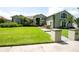 Well-manicured front yard of a charming green home, featuring lush lawn and colorful landscaping at 916 Bunker View Dr, Apollo Beach, FL 33572