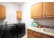 Well-equipped laundry room featuring modern Samsung washer and dryer units with ample cabinet space at 916 Bunker View Dr, Apollo Beach, FL 33572