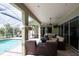 Relaxing screened-in patio featuring comfortable seating, a ceiling fan, and views of the pool at 916 Bunker View Dr, Apollo Beach, FL 33572