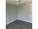 This bedroom features sleek gray walls, modern gray flooring, and a ceiling fan with a light fixture at 1 Windrush Blvd # 84, Indian Rocks Beach, FL 33785