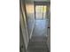 Bedroom with gray flooring that leads to a glass sliding door and small balcony, with a white closet nearby at 1 Windrush Blvd # 84, Indian Rocks Beach, FL 33785