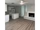 Open living area with modern floors, white fireplace, and updated kitchen access at 1 Windrush Blvd # 84, Indian Rocks Beach, FL 33785