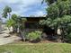 Screened-in back porch surrounded by lush landscaping and mature trees at 114 N Arcturas Ave, Clearwater, FL 33765