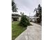 Backyard showcasing a covered patio, green foliage, and a view of the storage unit at 114 N Arcturas Ave, Clearwater, FL 33765