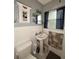 Cozy bathroom with pedestal sink, tiled walls, and a medicine cabinet with ample storage at 114 N Arcturas Ave, Clearwater, FL 33765