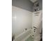 Bathroom features a shower-tub combination with white tile surround, and updated fixtures at 114 N Arcturas Ave, Clearwater, FL 33765
