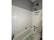 Bathroom features a shower-tub combination with white tile surround, and updated fixtures at 114 N Arcturas Ave, Clearwater, FL 33765