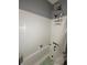 Clean white tiled bathroom with a shower/tub combination and essential toiletries at 114 N Arcturas Ave, Clearwater, FL 33765
