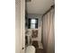 This bathroom features a pedestal sink, a window, and a shower with a curtain at 114 N Arcturas Ave, Clearwater, FL 33765