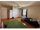 Cozy bedroom featuring hardwood floors, ceiling fan, and window with natural light at 114 N Arcturas Ave, Clearwater, FL 33765