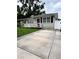Charming single-story home featuring a well-maintained lawn, a cozy porch, and a concrete driveway at 114 N Arcturas Ave, Clearwater, FL 33765