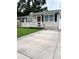 Charming single-story home featuring a well-maintained lawn, a cozy porch, and a concrete driveway at 114 N Arcturas Ave, Clearwater, FL 33765