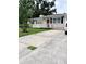Inviting one-story home with a manicured lawn and a spacious driveway, perfect for parking at 114 N Arcturas Ave, Clearwater, FL 33765