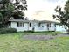 Cozy single-story home with green lawn and landscaping with flower beds in front at 114 N Arcturas Ave, Clearwater, FL 33765