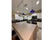 Bright kitchen with white cabinets, stainless steel appliances, brown countertops and unique hanging lights at 114 N Arcturas Ave, Clearwater, FL 33765