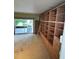 Living room features sliding glass door to patio and custom bookshelf with ladder at 114 N Arcturas Ave, Clearwater, FL 33765