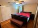 Cozy main bedroom featuring hardwood floors, a ceiling fan, and a closet with bi-fold doors at 114 N Arcturas Ave, Clearwater, FL 33765