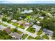 Aerial view of a neighborhood featuring a pool, green landscaping and a nearby lake at 1251 Fairway Dr, Dunedin, FL 34698