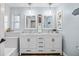 Well-lit bathroom with a double sink vanity, marble countertop, and modern fixtures at 1251 Fairway Dr, Dunedin, FL 34698