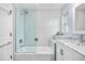 Bright bathroom featuring subway tile, glass shower door, and a marble vanity top at 1251 Fairway Dr, Dunedin, FL 34698