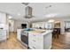 Modern kitchen featuring white cabinets, stainless steel hood vent, island seating and pendant lighting at 1251 Fairway Dr, Dunedin, FL 34698
