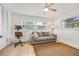 Cozy living room with a comfortable sofa, neutral decor, and natural light from the windows at 1251 Fairway Dr, Dunedin, FL 34698