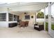 Covered patio with an outdoor dining table and comfortable seating area for relaxation and entertaining at 1251 Fairway Dr, Dunedin, FL 34698