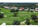 Aerial view of a golf course neighborhood featuring mature trees and lush greenery at 12713 Grand Traverse Dr, Dade City, FL 33525