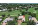 An aerial view of a well-maintained home, golf course, and beautiful landscaping with mature trees and lawn at 12713 Grand Traverse Dr, Dade City, FL 33525