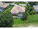 Aerial view of home with screened pool, well-manicured lawn, and lush landscaping at 12713 Grand Traverse Dr, Dade City, FL 33525