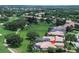 A stunning aerial view of a beautiful home near a golf course, nestled within lush greenery at 12713 Grand Traverse Dr, Dade City, FL 33525
