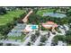 Aerial view of tennis and pool club featuring lush greenery and mature trees at 12713 Grand Traverse Dr, Dade City, FL 33525