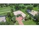 Aerial view of home with lush landscape, brick paved driveway, and mature trees at 12713 Grand Traverse Dr, Dade City, FL 33525