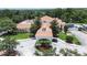 Aerial view of a clubhouse featuring lush landscape, mature trees, and covered entry at 12713 Grand Traverse Dr, Dade City, FL 33525