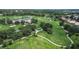 Aerial view of golf course with surrounding trees and residences nearby at 12713 Grand Traverse Dr, Dade City, FL 33525