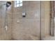 Modern bathroom shower featuring a TV, showerhead, and stylish stone tiling at 12713 Grand Traverse Dr, Dade City, FL 33525