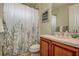 Cozy bathroom with a floral-themed shower curtain and a classic vanity at 12713 Grand Traverse Dr, Dade City, FL 33525
