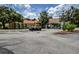 Community clubhouse featuring a convenient carport, multiple golf carts, and lush landscaping at 12713 Grand Traverse Dr, Dade City, FL 33525