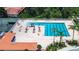 Aerial shot of a beautiful community pool with seating, umbrellas, and palm trees at 12713 Grand Traverse Dr, Dade City, FL 33525